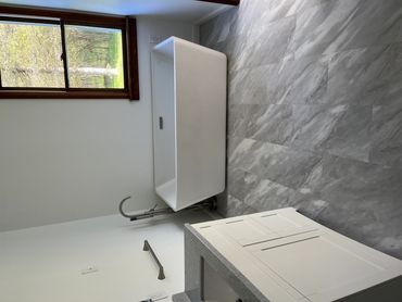 Modern bathroom with a standalone white bathtub and gray marble floor.