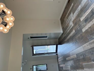 Empty room with wooden flooring and modern chandelier.