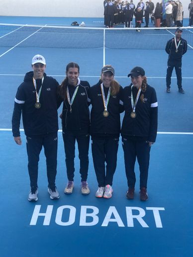 Four tennis players with medals standing on a Hobart tennis court.