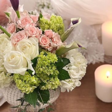 Green hydrangeas, pink roses and calla lilies in a ceramic vase. Wedding centerpiece 