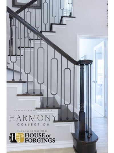 Elegant black stair railing with geometric iron balusters in a bright home.
