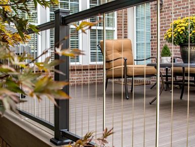 Cozy outdoor patio with cushioned chairs and modern cable railing.