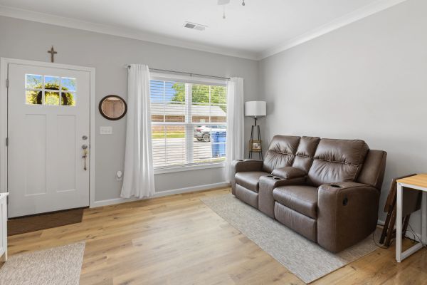 Cozy living room with brown leather recliner sofa and large window.