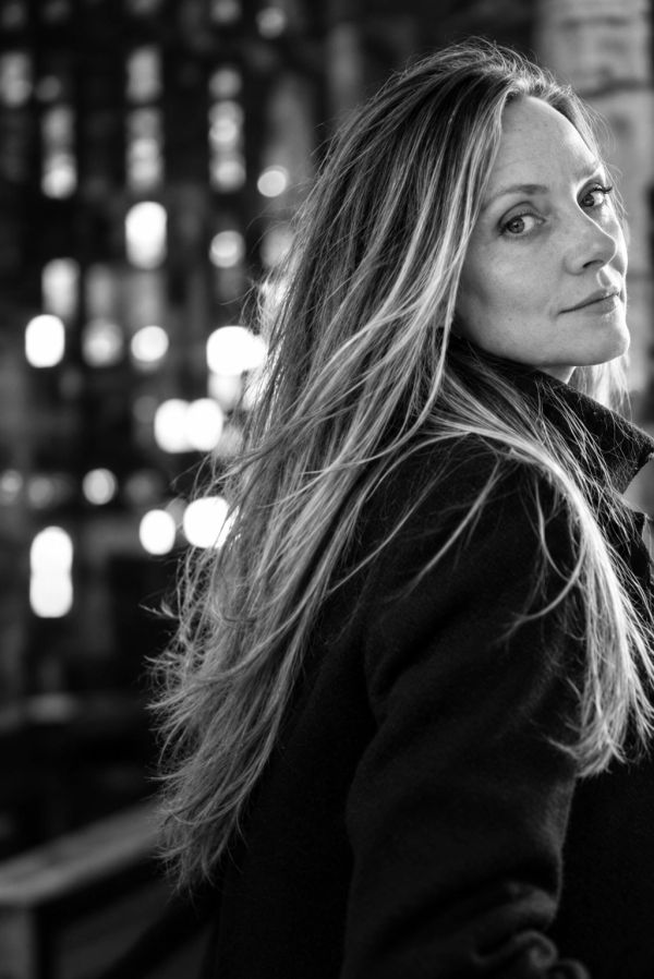 Colleen Ann Murphy, MD, in a black coat, looking over her shoulder against city lights.