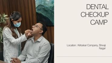 A dentist checks a patient's teeth during a dental camp at Kirloskar Company.