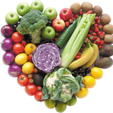 A heart-shaped arrangement of fresh fruits and vegetables.