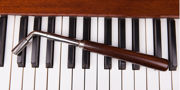 Wooden clarinet resting on piano keys with a polished wood finish.