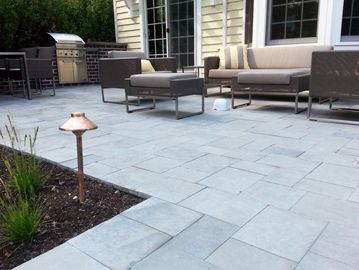 Natural Bluestone patio and garden walk feature integrated into a lush backyard landscape.