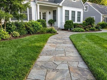 Natural irregular flagstone step walkway leading through a green lawn in Waldwick.