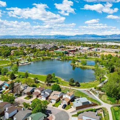 A suburban neighborhood surrounding a large pond with mountains in the distance.