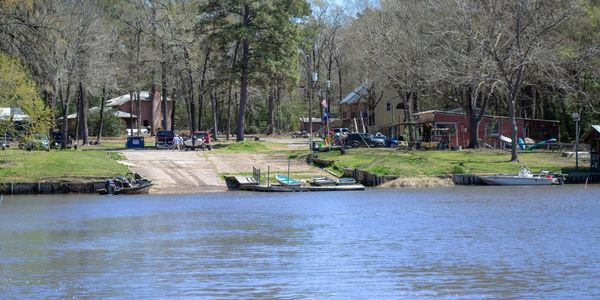 Calm riverside with boats and houses along the shore.