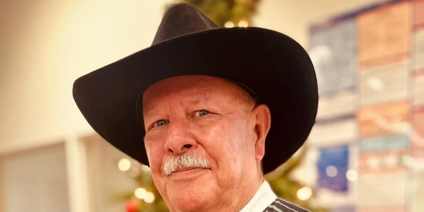 Elderly man in a black cowboy hat with a mustache.