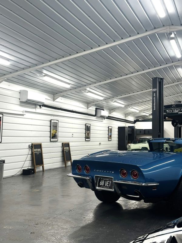 Blue Corvette parked inside a clean, well-lit garage.