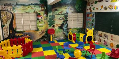 Colorful children's playroom with educational mural and toys.