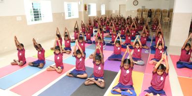 Children practicing yoga in a spacious hall.