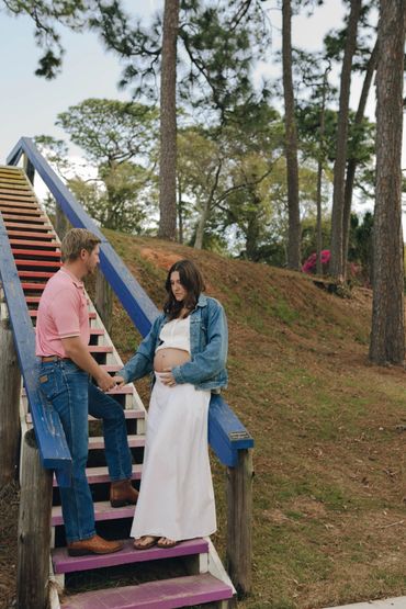 Couple sharing a tender moment on colorful stairs in nature.