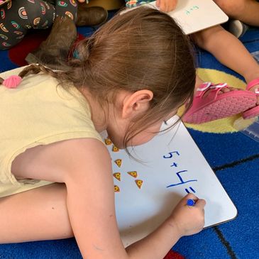 Preschool student solves addition problems