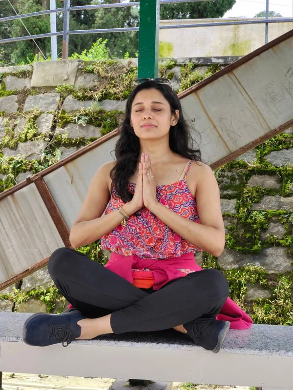 Young woman meditating outdoors in a peaceful setting.