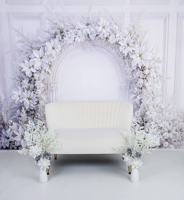 Elegant white floral arch with a white couch.