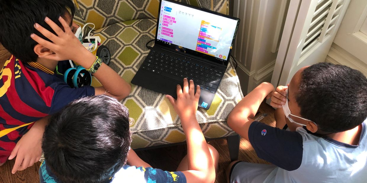 Kids learning to code with LEGO SPIKE Prime kits.