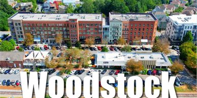 Aerial view of Woodstock with mixed-use buildings and parking lots.