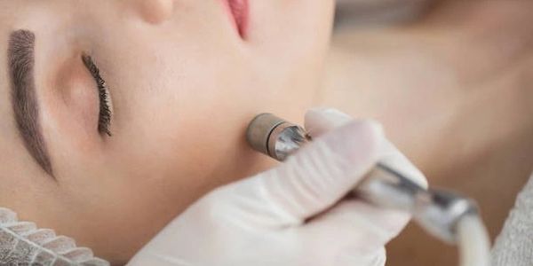 Woman relaxing during microdermabrasion facial treatment at Autumn Noel Esthetics