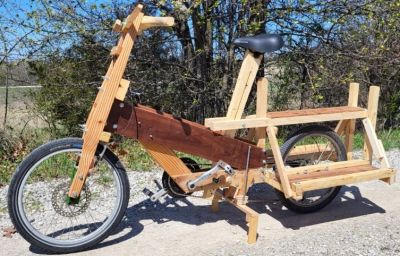 A wooden bicycle with a cargo rack on the back.