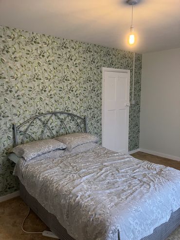 Bedroom in Dane Hill redecorated with a feature wall in a patterned wall paper