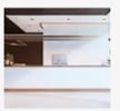 Modern, minimalist kitchen with sleek white countertops and wooden cabinetry.