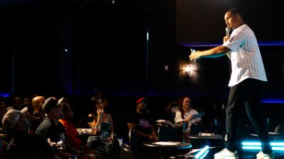 A performer engaging an attentive audience on stage.