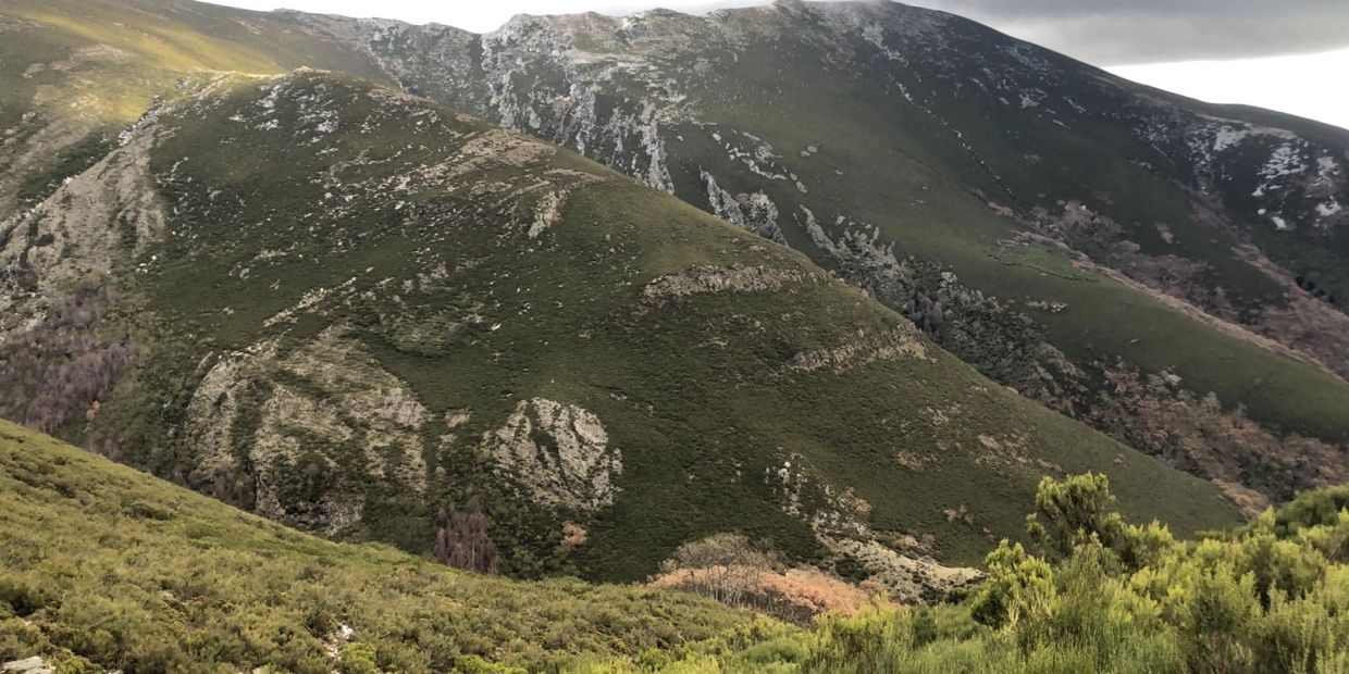 Montañas verdes con vegetación y cielo nublado.