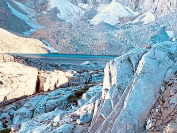 A rocky mountain landscape with a winding road cutting through it.