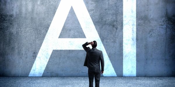 Man in suit staring at large AI letters on wall.