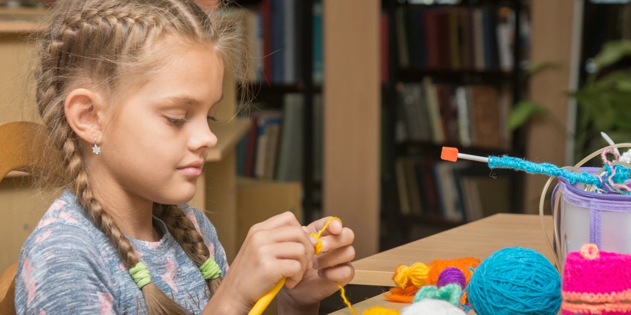 Girl knitting colorful yarn at UMAI Foundation class — building confidence and creativity. 