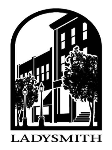 Black and white city street scene with buildings and trees.