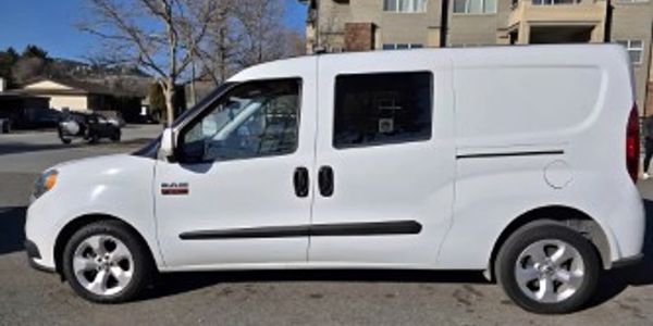 White cargo van parked on a residential street in daylight.