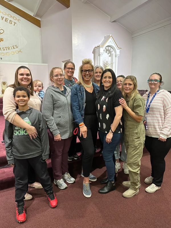 A diverse group of people smiling indoors in a casual setting.