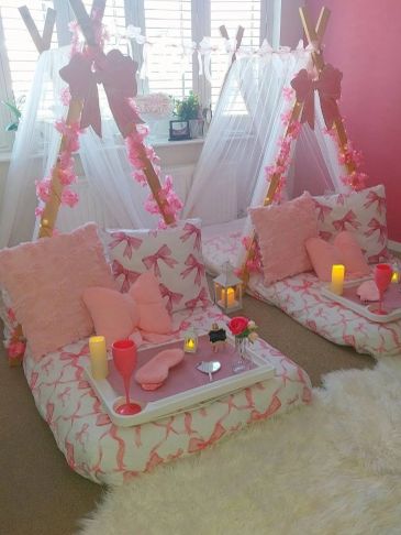 Cozy pink-themed indoor teepee sleepover setup.