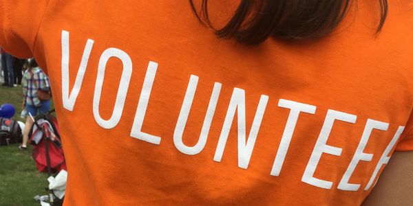 Orange shirt with the word VOLUNTEER printed in white.