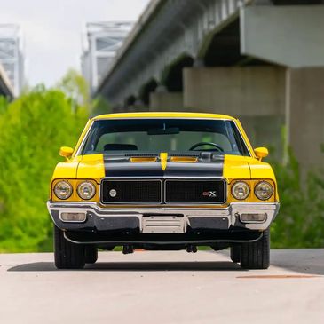 Front view of a yellow classic muscle car.