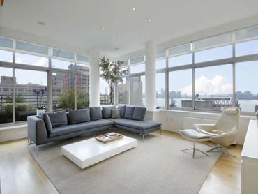 Modern living room with large windows and gray sectional sofa.