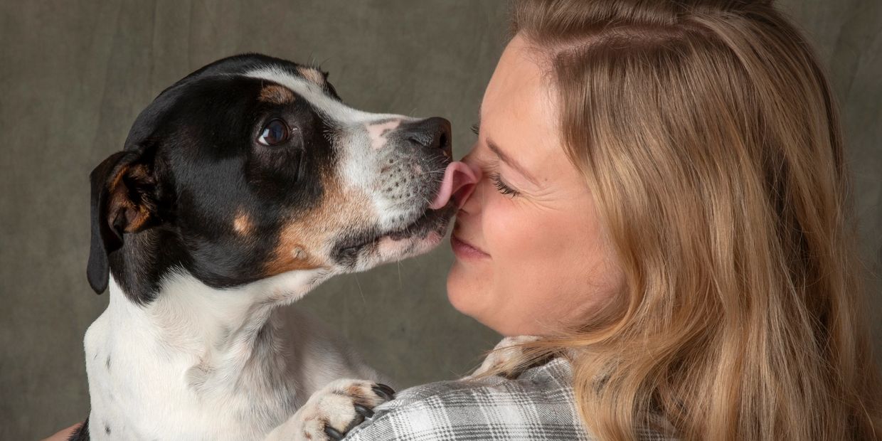 Dog licking Dog Trainers face