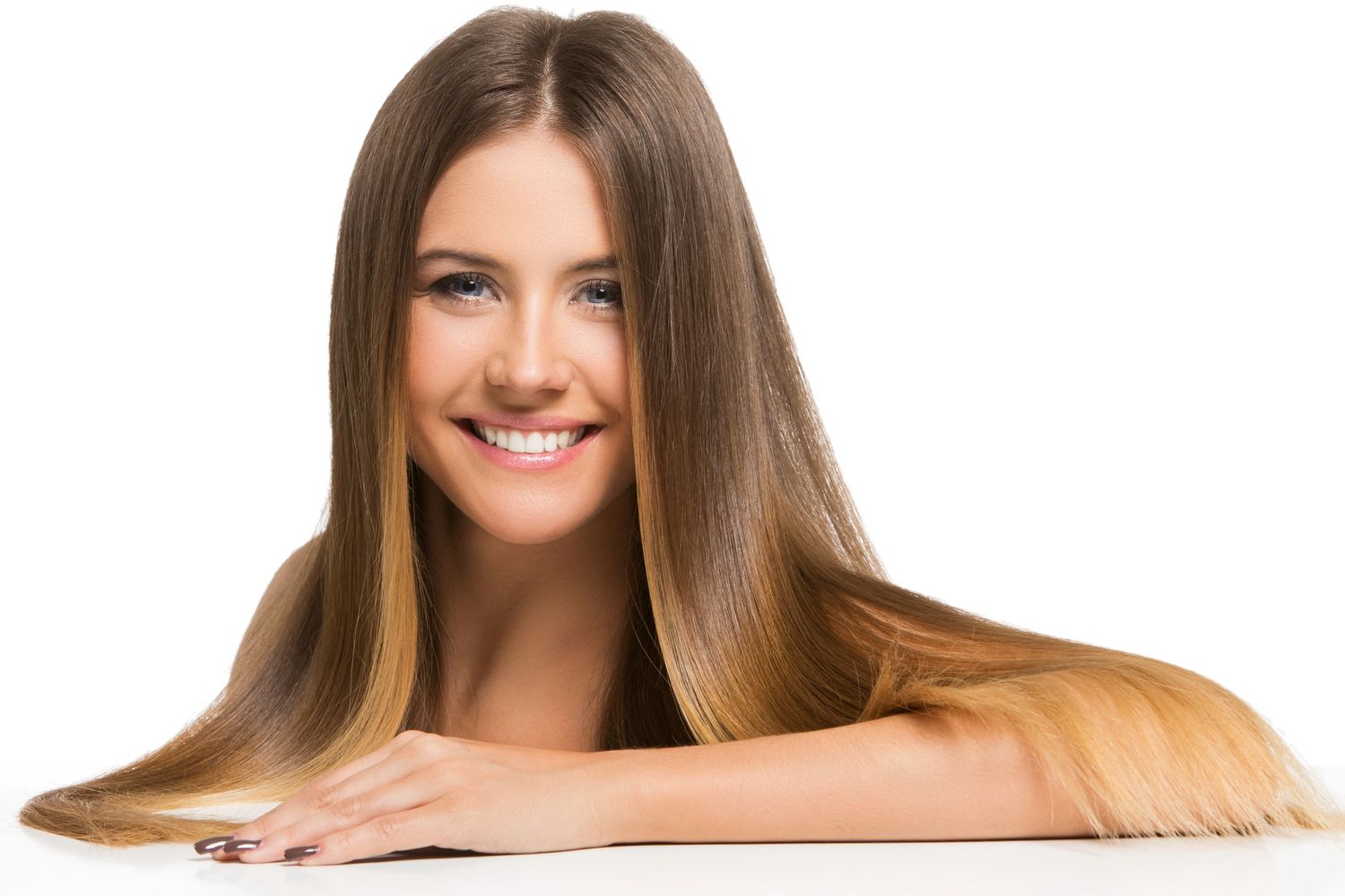 Smiling woman with long, straight hair resting her arms on a surface.