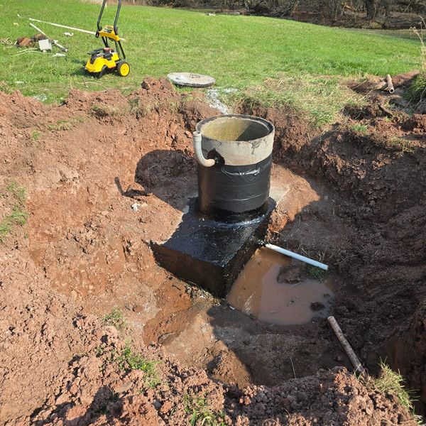 repaired septic tank or drainage system in a dug-out area of soil.