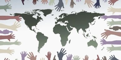Diverse hands reaching toward a world map, symbolizing global unity and cooperation.