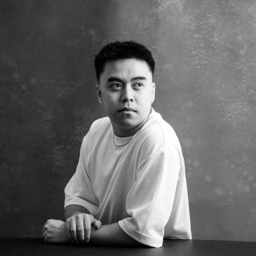 Black and white portrait of a man looking sideways with a neutral expression.