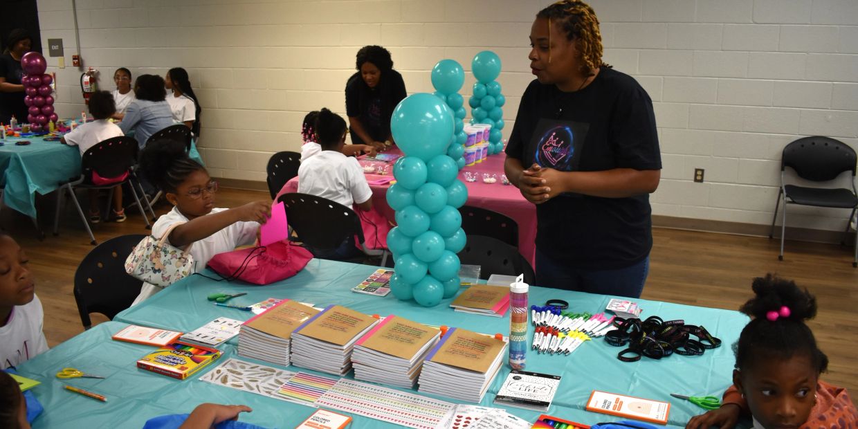 Children and an instructor engage in a creative workshop with supplies and balloons.