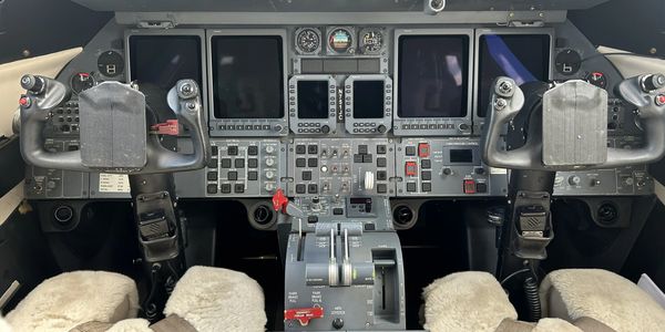Cockpit of a modern aircraft with control panels and seats.