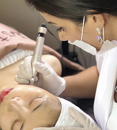 A professional performing a facial treatment on a client.