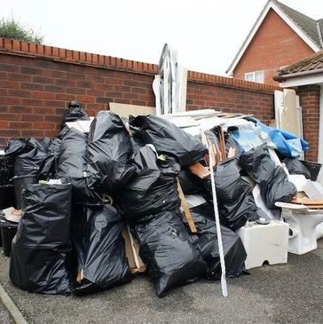 EZJUNK.com cleaning large pile of junk and garbage bags. 